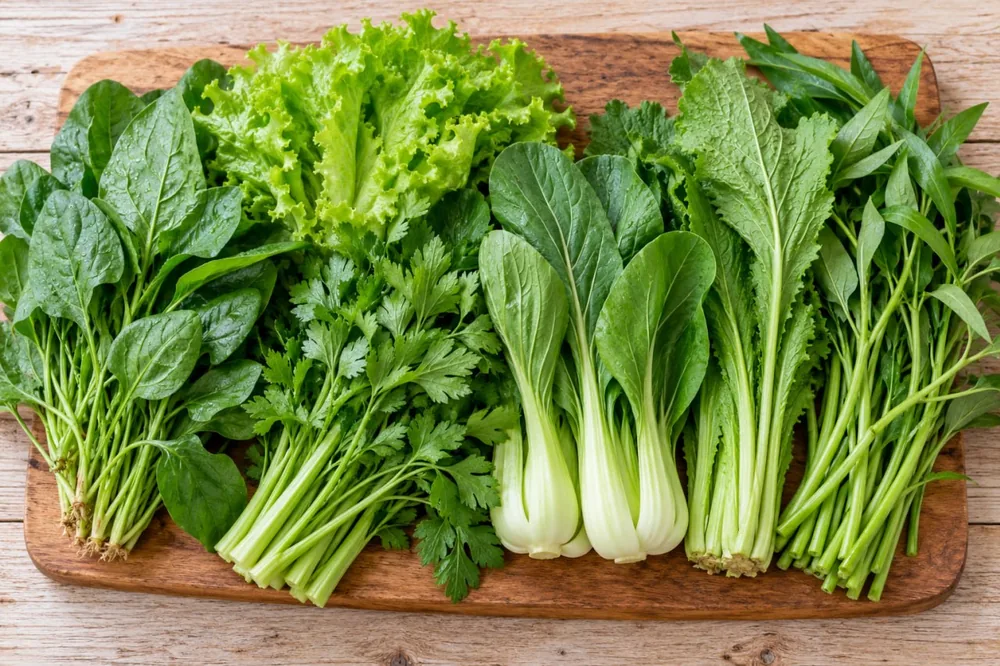 Aneka sayuran hijau untuk jantung di atas talenan: bayam, selada, peterseli, pakcoy, sawi, dan kangkung